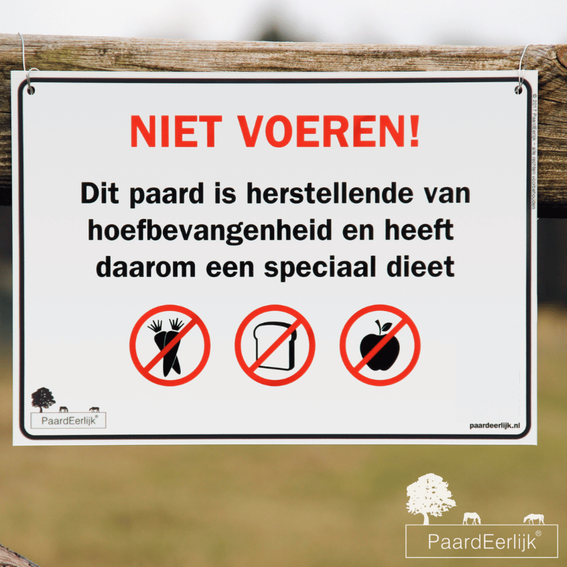 Niet voeren bord voor paard herstellende van hoefbevangenheid, bevestigd aan weide afrastering.