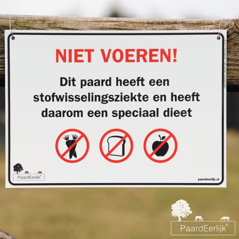 Niet voeren bord voor paard met stofwisselingsziekte bevestigd aan weide afrastering.