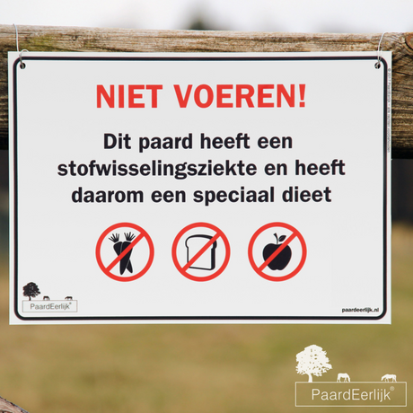 Niet voeren bord voor paard met stofwisselingsziekte bevestigd aan weide afrastering.