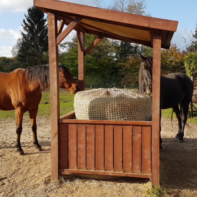 hooihuisje met hooibaalnet en twee paarden